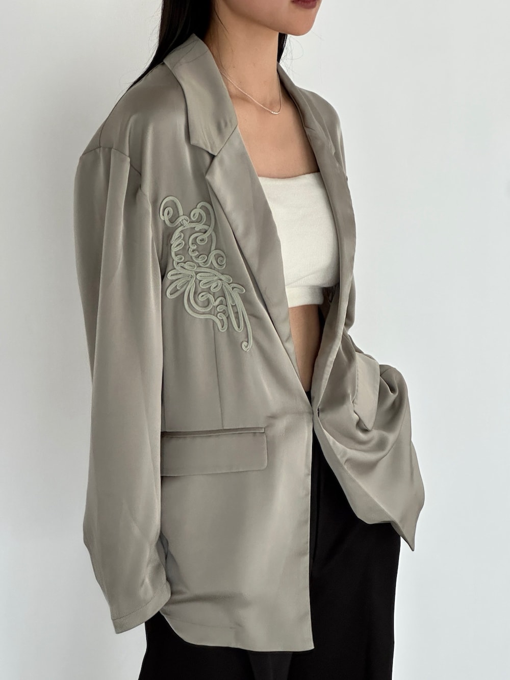 グリーン系のテーラードジャケット、ブラック系のその他パンツを着用したレディースの秋コーディネートの4枚目の写真