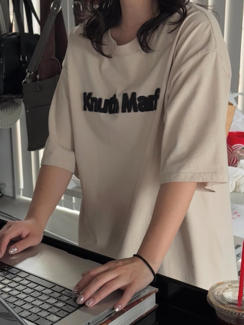 ベージュ系のTシャツ/カットソーを着用したレディースの夏コーディネートの2枚目の写真