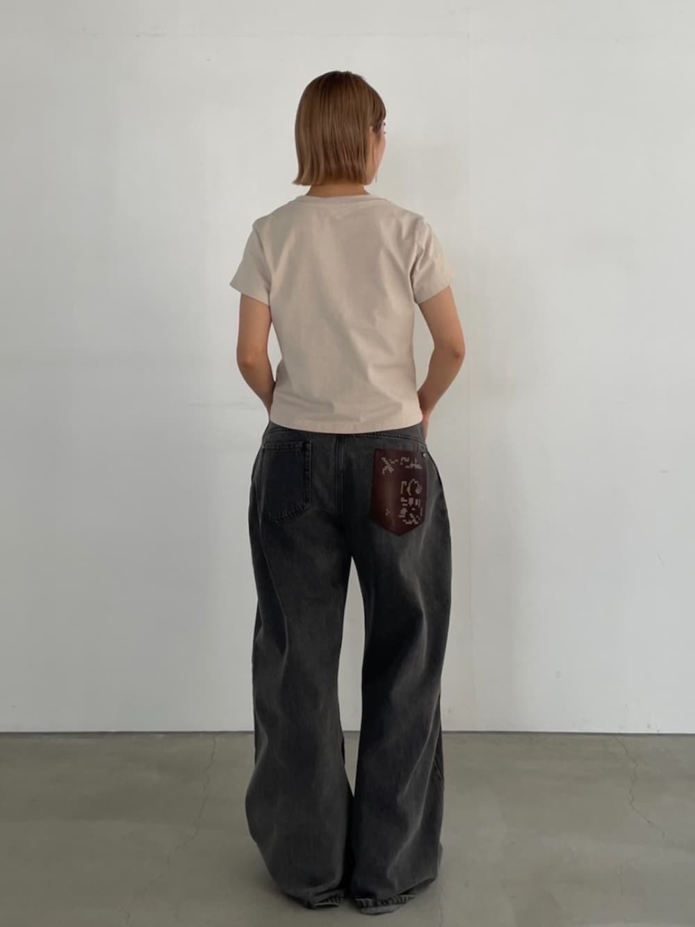 ベージュ系のTシャツ/カットソー、グレー系のデニムパンツを着用したレディースの夏コーディネートの5枚目の写真