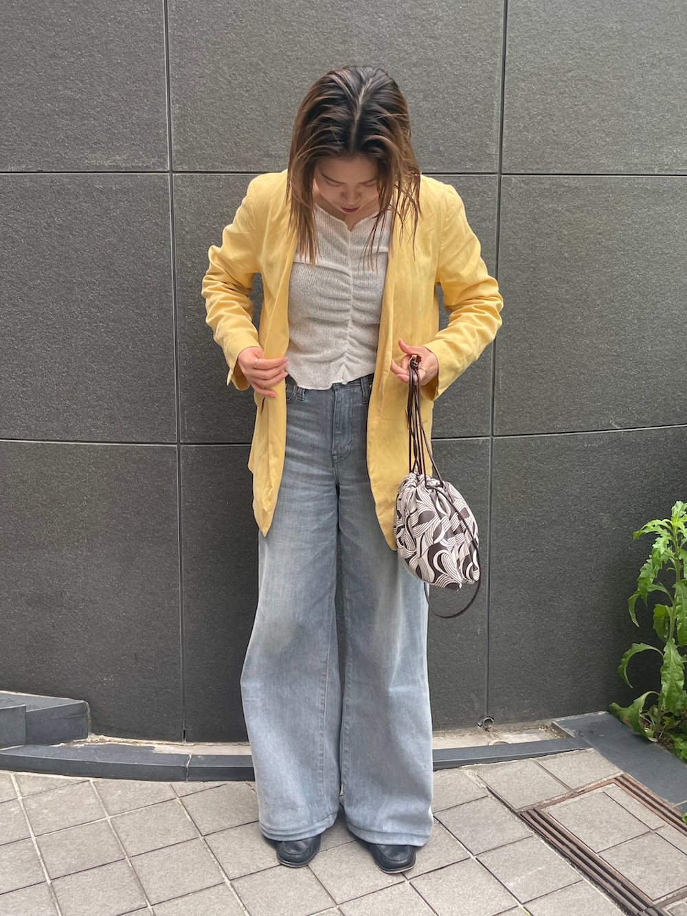 グレー系のデニムパンツ、ホワイト系のTシャツ/カットソー、イエロー系のジャケット/アウターを着用したレディースの春コーディネートの2枚目の写真