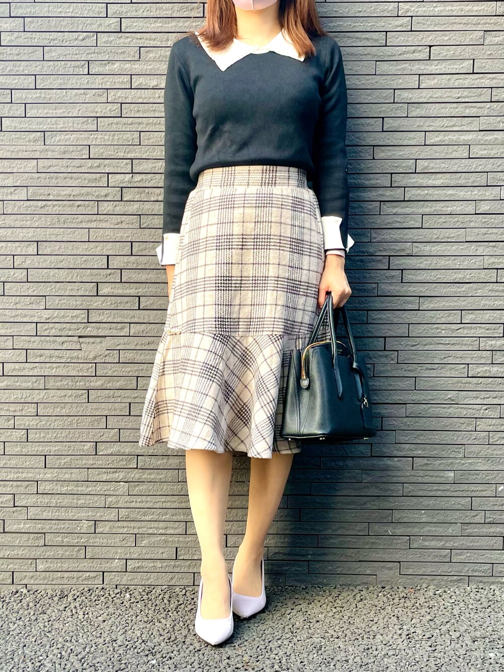 ベージュ系のライダースジャケット、ベージュ系のスカート、ホワイト系のパンプスを着用したレディースの春コーディネートの2枚目の写真