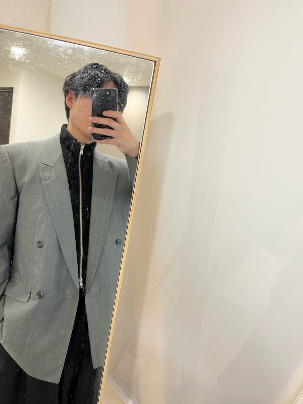 グレー系のテーラードジャケット、ホワイト系のTシャツ/カットソー、ブラック系のニット/セーターを着用したメンズの冬コーディネートの2枚目の写真