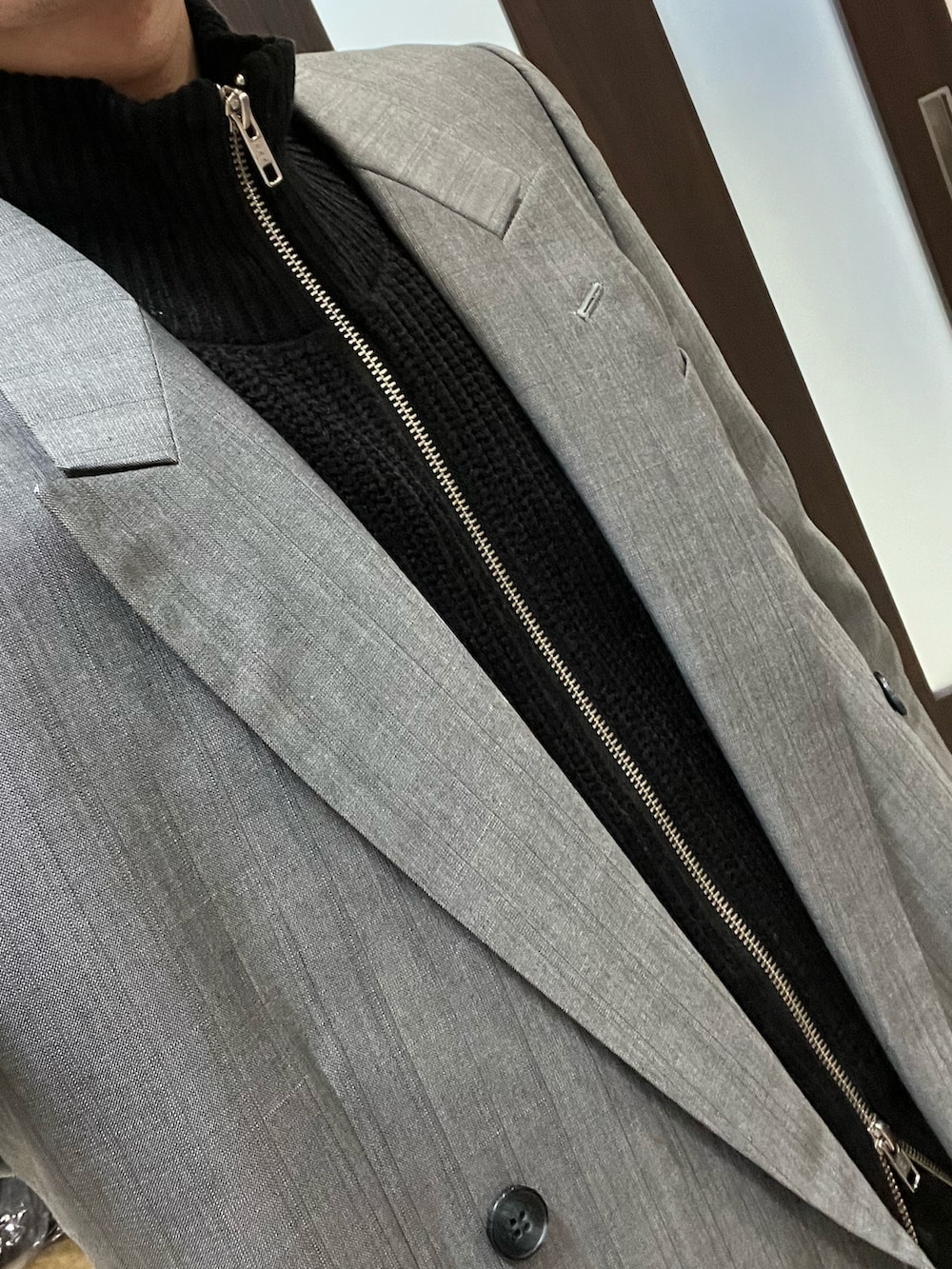 グレー系のテーラードジャケット、ホワイト系のTシャツ/カットソー、ブラック系のニット/セーターを着用したメンズの冬コーディネートの3枚目の写真