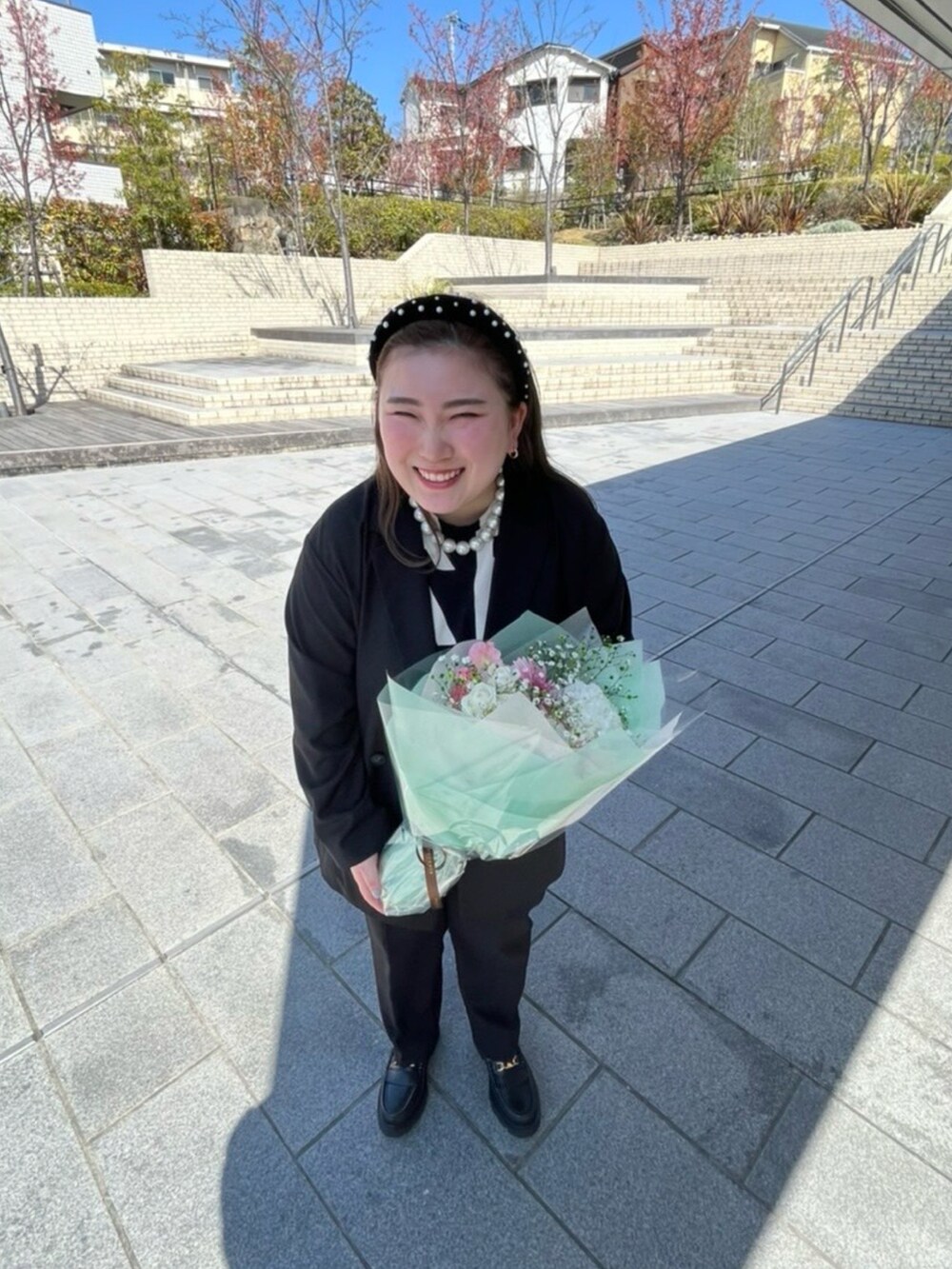 ブラック系のテーラードジャケット、ブラック系のバッグ、ブラック系のローファーを着用したレディースの春コーディネートの2枚目の写真