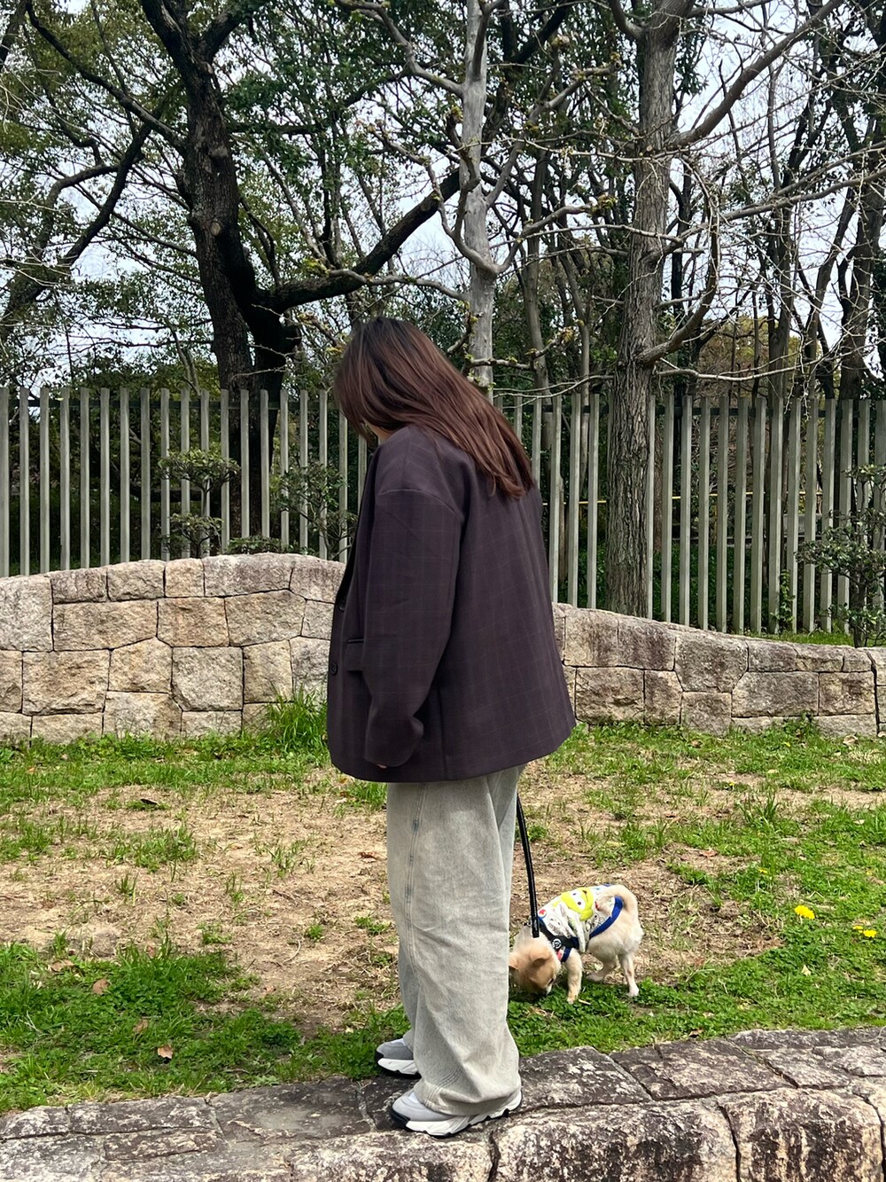 ブラウン系のテーラードジャケット、レッド系のTシャツ/カットソー、ブルー系のデニムパンツを着用したレディースの春コーディネートの3枚目の写真