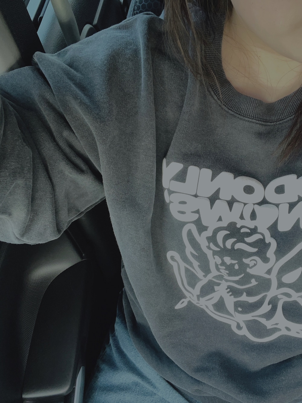 ブラック系のスウェット、ブルー系のデニムパンツ、ブラック系のハンドバッグを着用したレディースの秋コーディネートの3枚目の写真