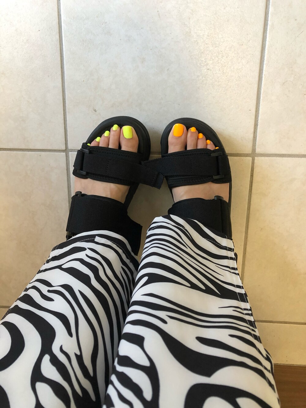 ブラック系のタンクトップ、イエロー系のトートバッグ、ブラック系のサンダルを着用したレディースの夏コーディネートの3枚目の写真