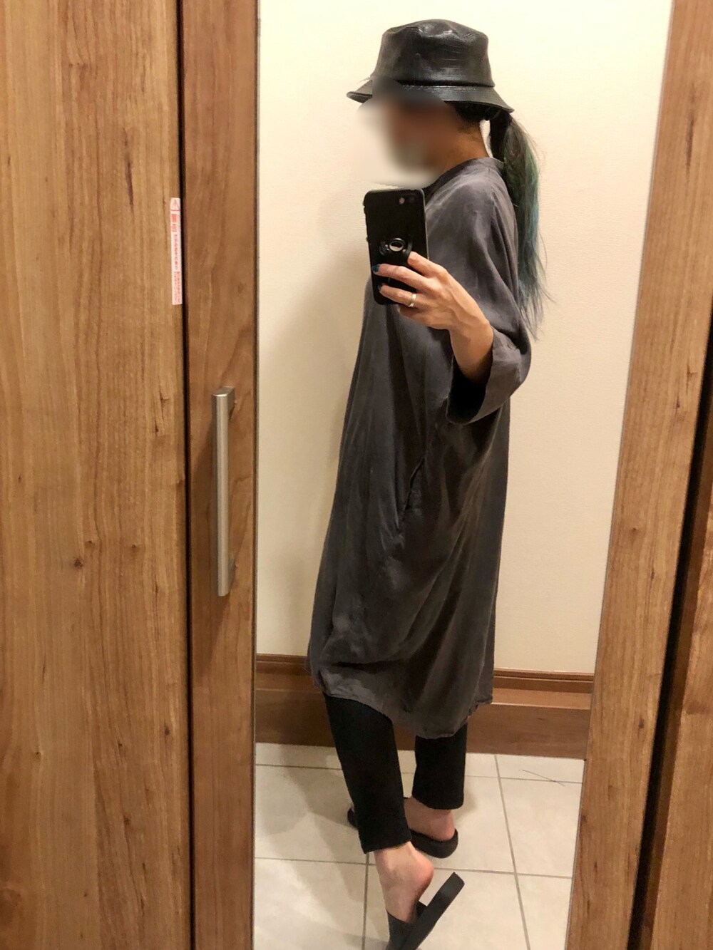 グレー系のシャツワンピース、ブラック系のパンツ、ブラック系のサンダルを着用したレディースの夏コーディネートの2枚目の写真