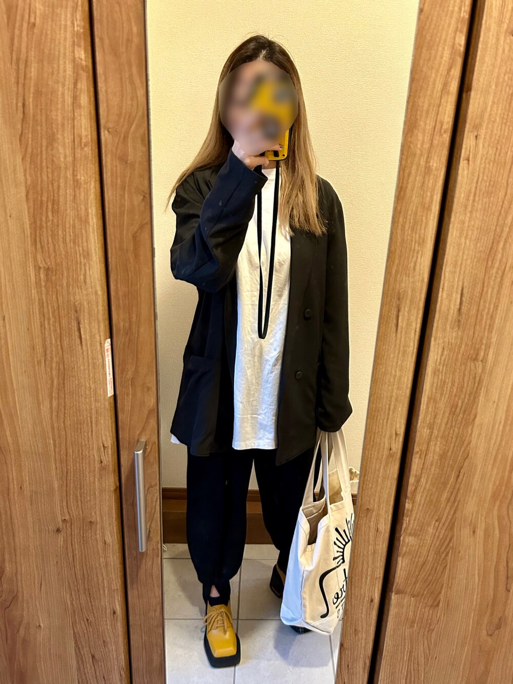 ブラック系のテーラードジャケット、ブラック系のその他パンツ、イエロー系のドレスシューズを着用したレディースの冬コーディネートの2枚目の写真