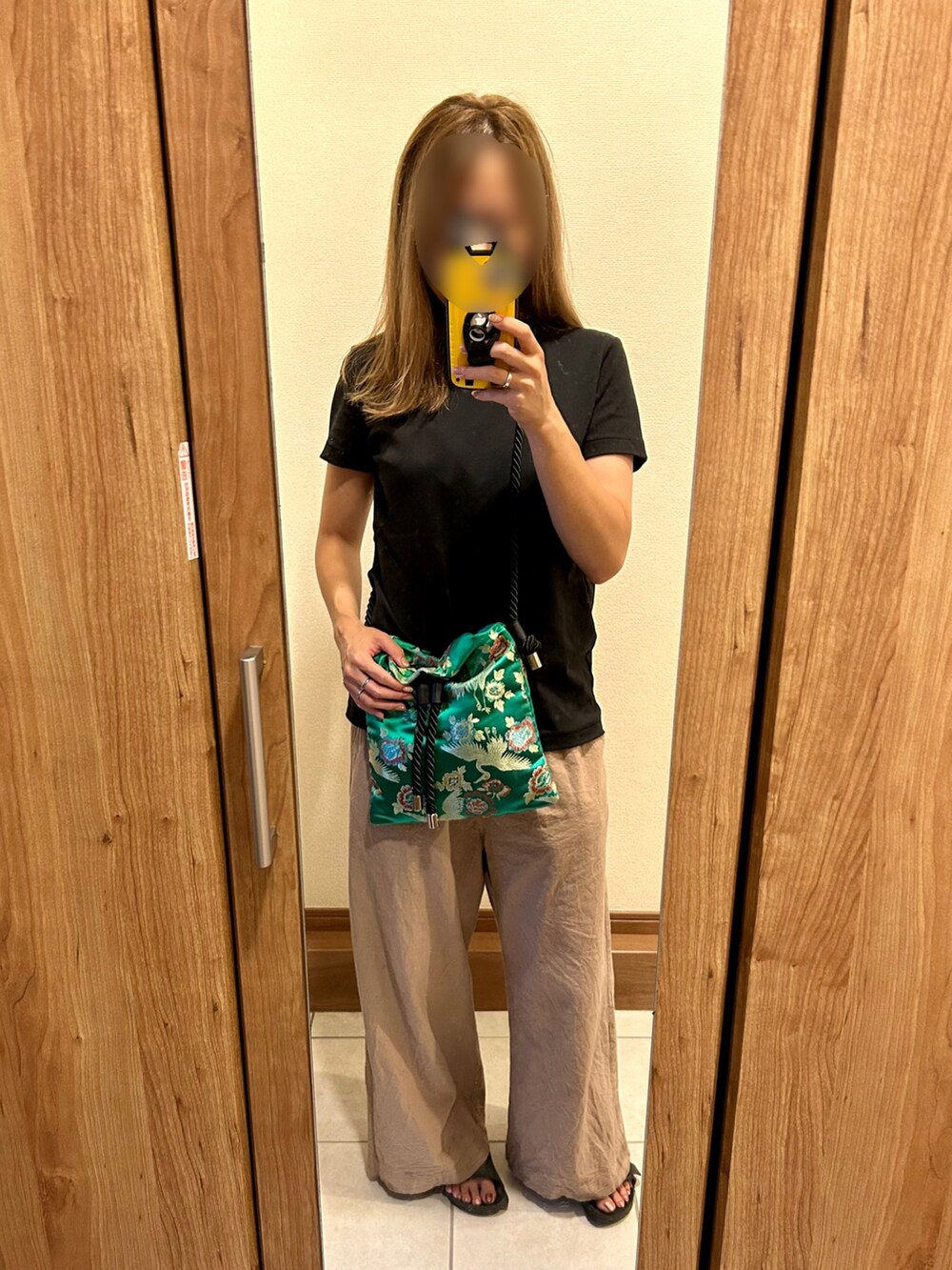 ブラック系のTシャツ/カットソー、グリーン系のバッグ、ベージュ系のパンツを着用したレディースの夏コーディネートの2枚目の写真