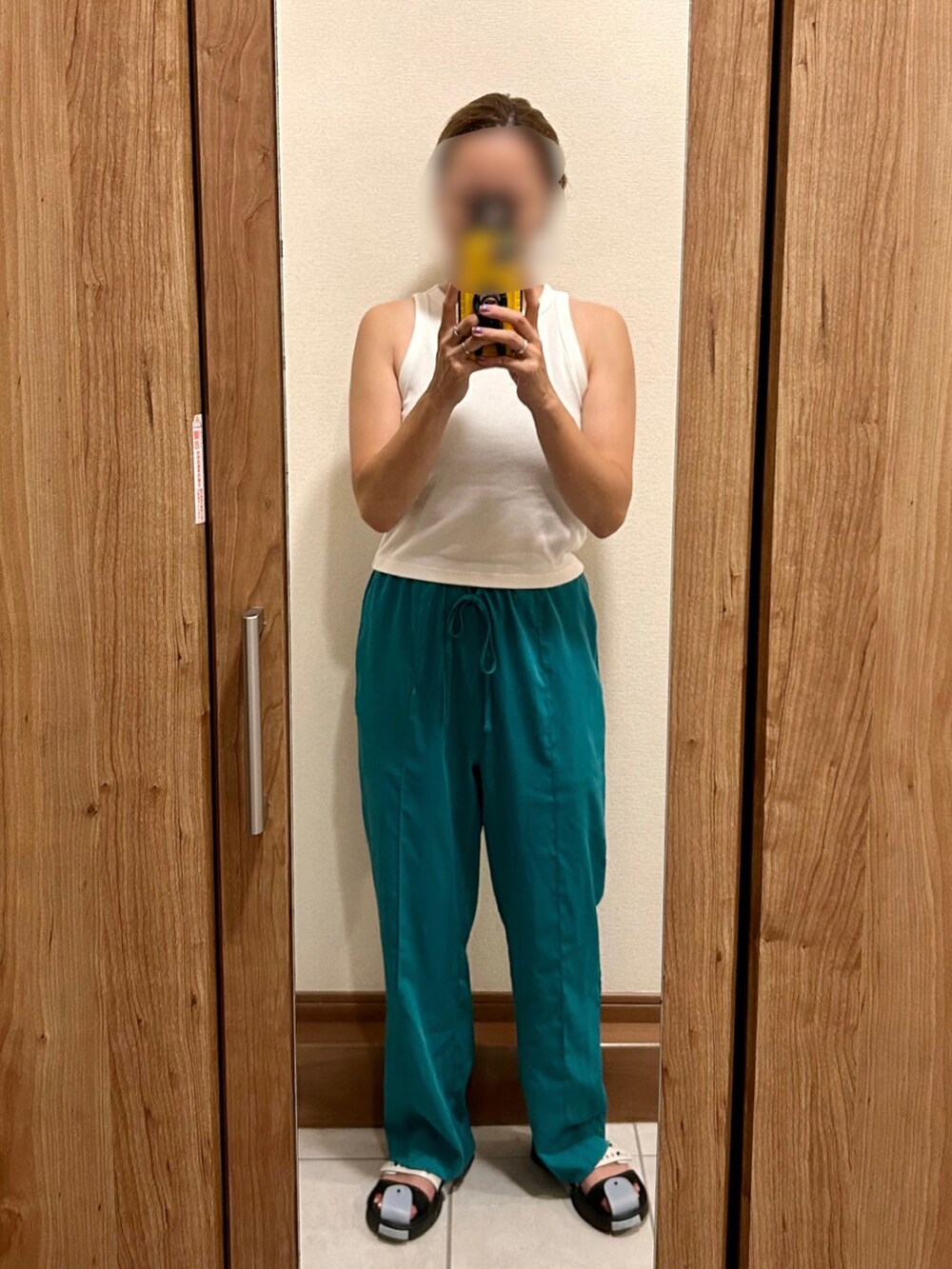 グリーン系のスラックス、ホワイト系のタンクトップ、ブルー系のサンダルを着用したレディースの夏コーディネートの2枚目の写真