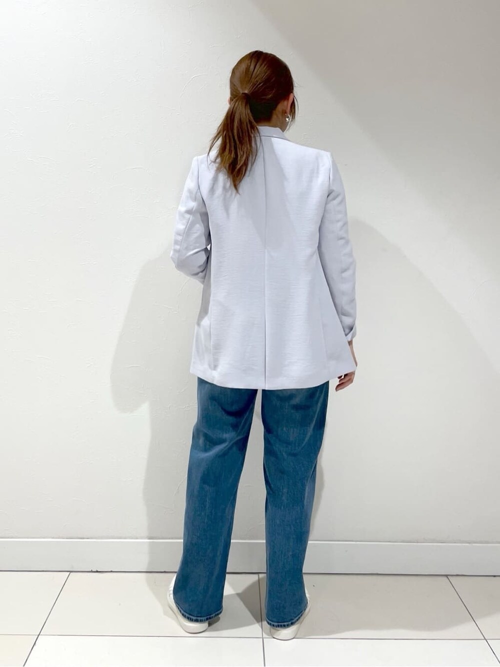 グレー系のスーツジャケット、ホワイト系のシャツ/ブラウス、ブルー系のデニムパンツを着用したレディースの夏コーディネートの6枚目の写真