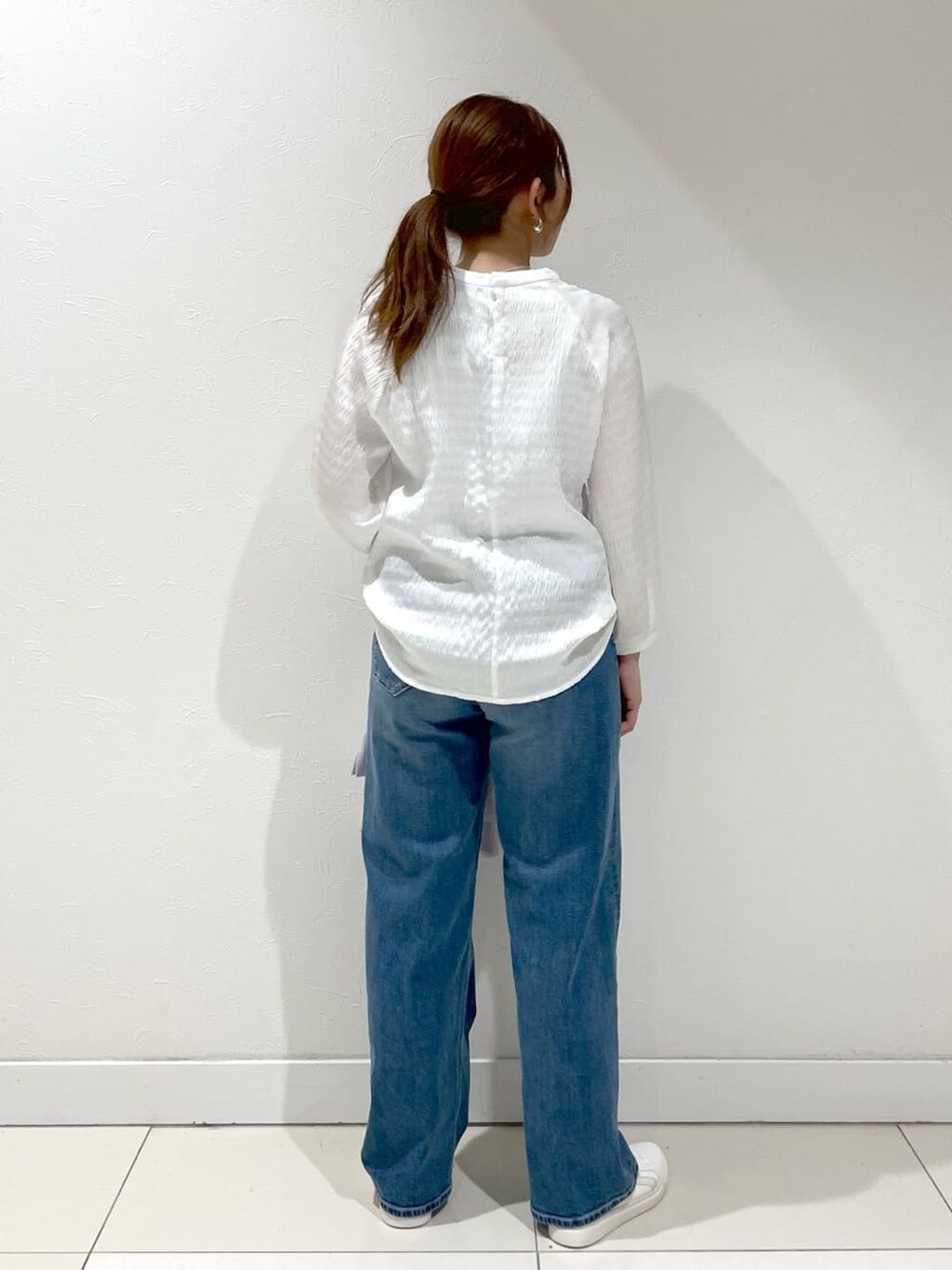 グレー系のスーツジャケット、ホワイト系のシャツ/ブラウス、ブルー系のデニムパンツを着用したレディースの夏コーディネートの3枚目の写真