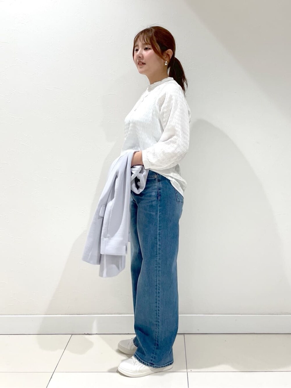 グレー系のスーツジャケット、ホワイト系のシャツ/ブラウス、ブルー系のデニムパンツを着用したレディースの夏コーディネートの2枚目の写真