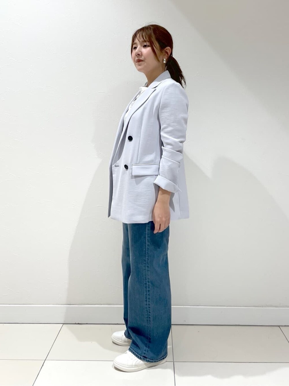 グレー系のスーツジャケット、ホワイト系のシャツ/ブラウス、ブルー系のデニムパンツを着用したレディースの夏コーディネートの5枚目の写真