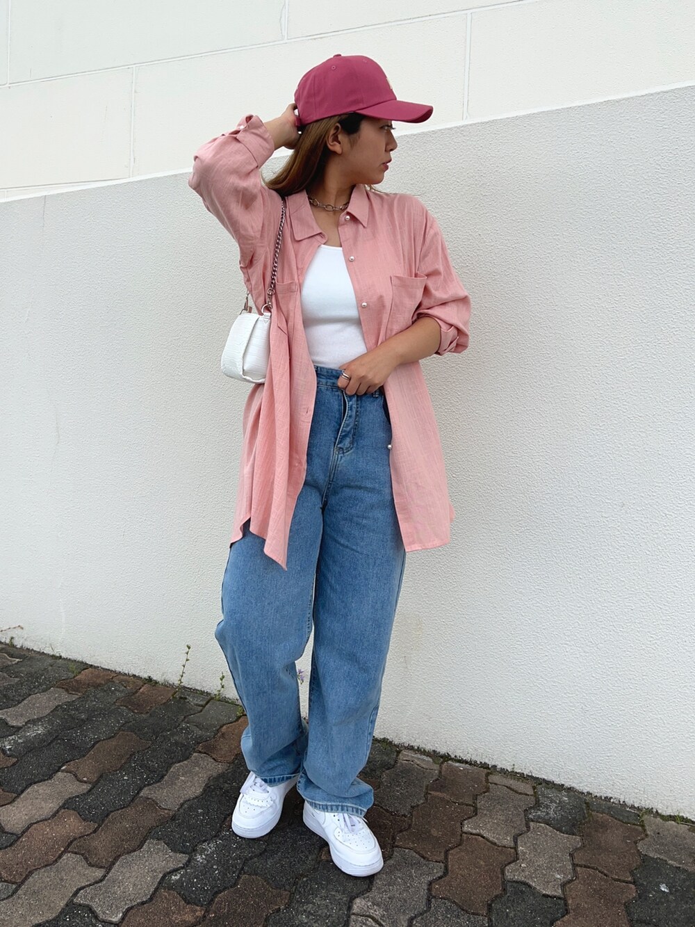 ブルー系のデニムパンツ、ホワイト系のスニーカー、ホワイト系のキャミソールを着用したレディースの夏コーディネートの2枚目の写真