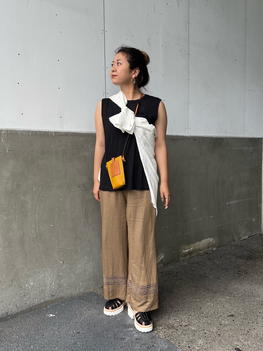 ブラウン系のその他パンツ、ブラック系のサンダル、イエロー系のショルダーバッグを着用したレディースの夏コーディネートの2枚目の写真