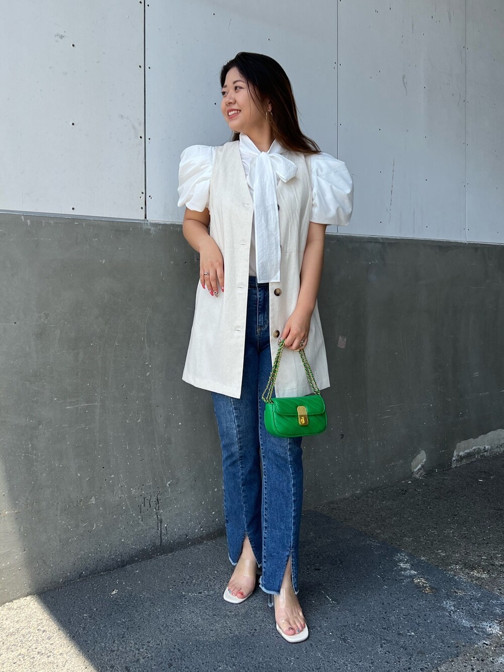 ホワイト系のシャツ/ブラウス、ベージュ系のベスト、ブラック系のショルダーバッグを着用したレディースの夏コーディネートの2枚目の写真