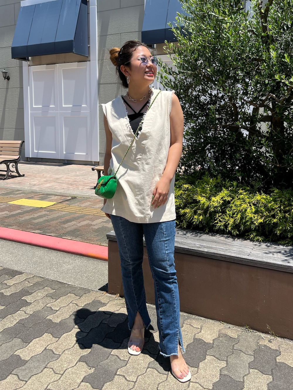 ホワイト系のシャツ/ブラウス、ホワイト系のサンダル、ブルー系のデニムパンツを着用したレディースの夏コーディネートの2枚目の写真