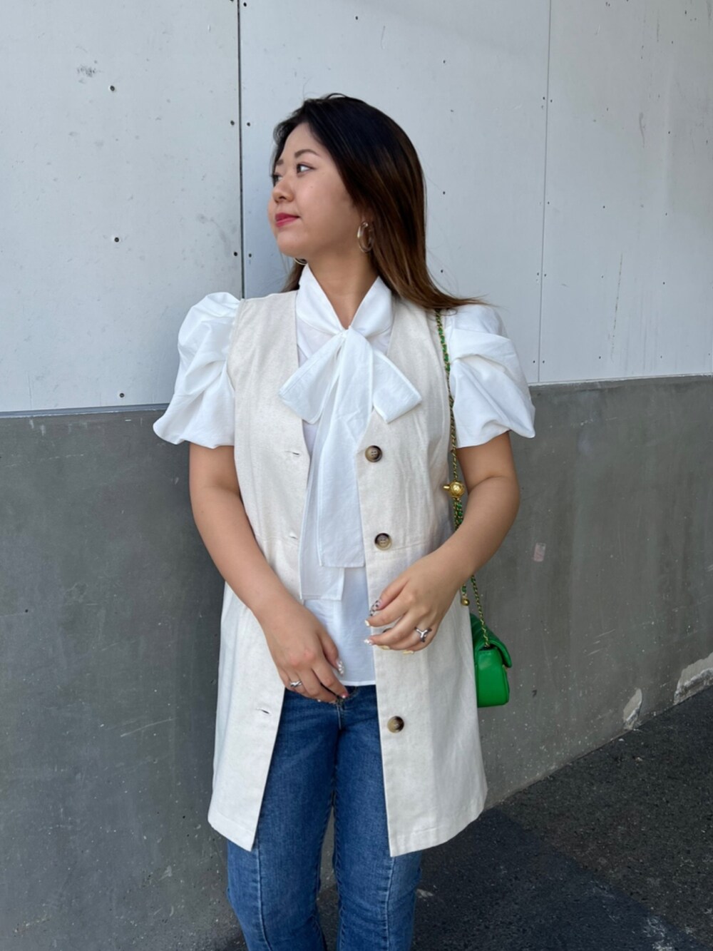 ホワイト系のシャツ/ブラウス、ベージュ系のベスト、ブラック系のショルダーバッグを着用したレディースの夏コーディネートの3枚目の写真