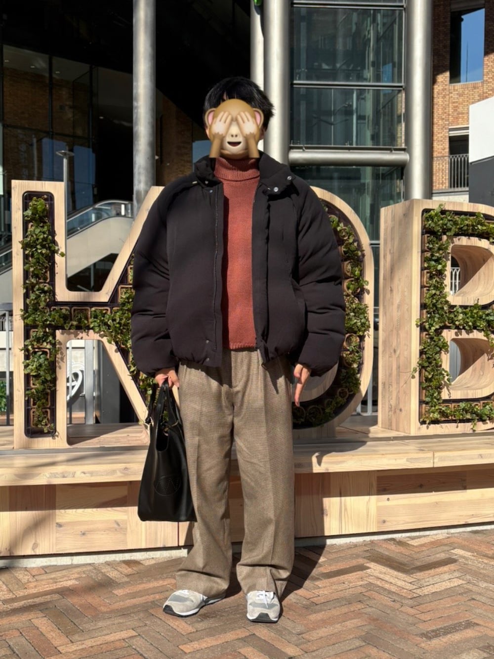 ブラウン系のスラックス、グレー系のスニーカーを着用したメンズの冬コーディネートの2枚目の写真