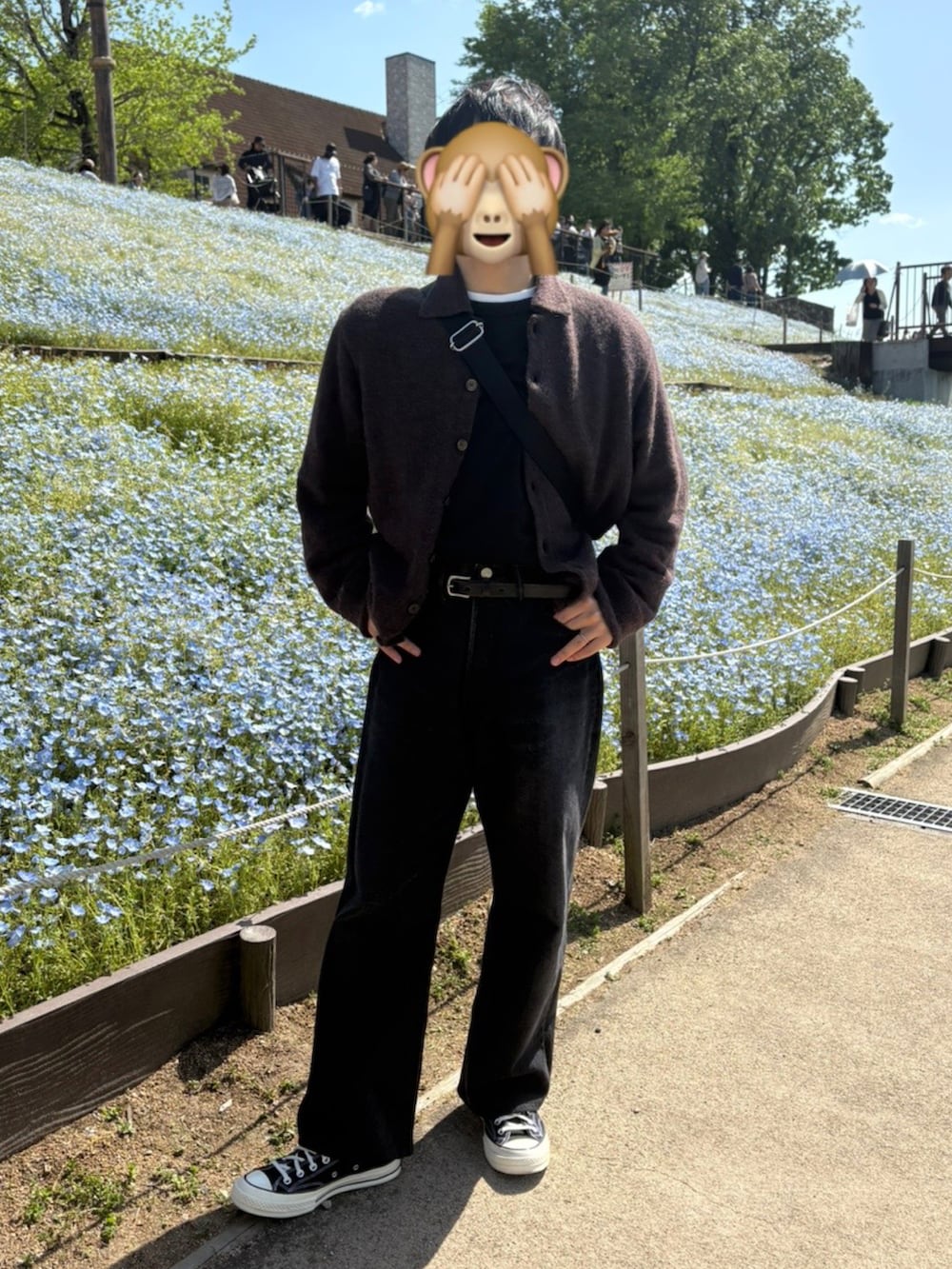 ブラウン系のカーディガン/ボレロ、ブラック系のデニムパンツ、ブラック系のスニーカーを着用したメンズの春コーディネートの2枚目の写真