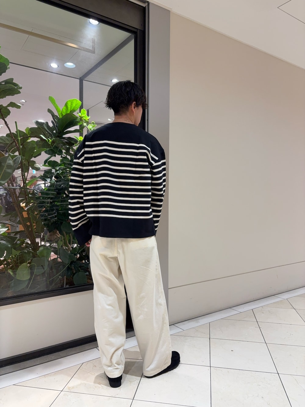 ブラック系のTシャツ/カットソー、ホワイト系のその他パンツ、ブラウン系のトートバッグを着用したメンズの秋コーディネートの3枚目の写真