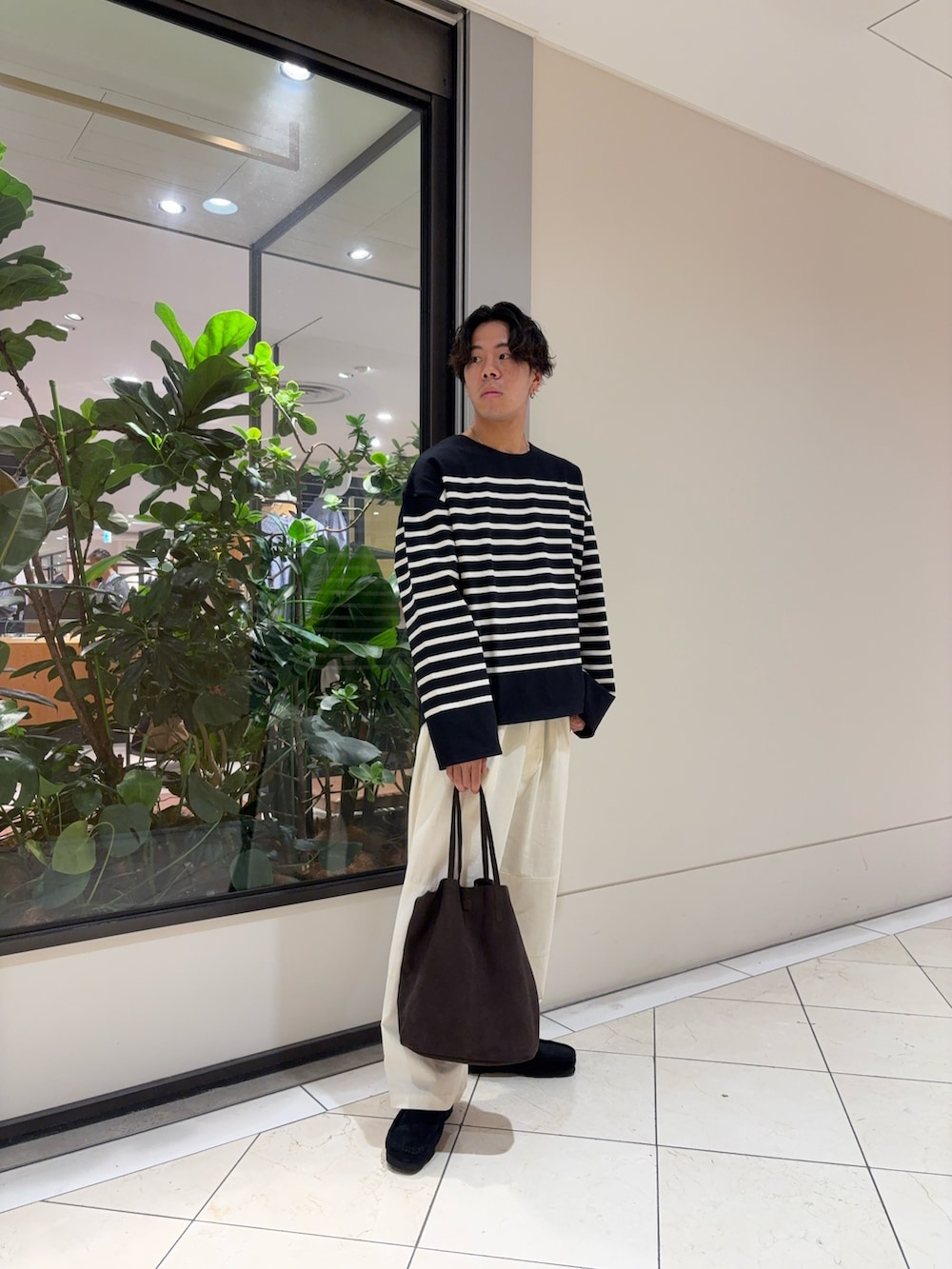 ブラック系のTシャツ/カットソー、ホワイト系のその他パンツ、ブラウン系のトートバッグを着用したメンズの秋コーディネートの2枚目の写真
