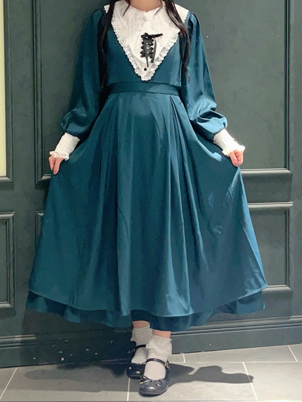 グリーン系のワンピースを着用したレディースの秋コーディネートの4枚目の写真