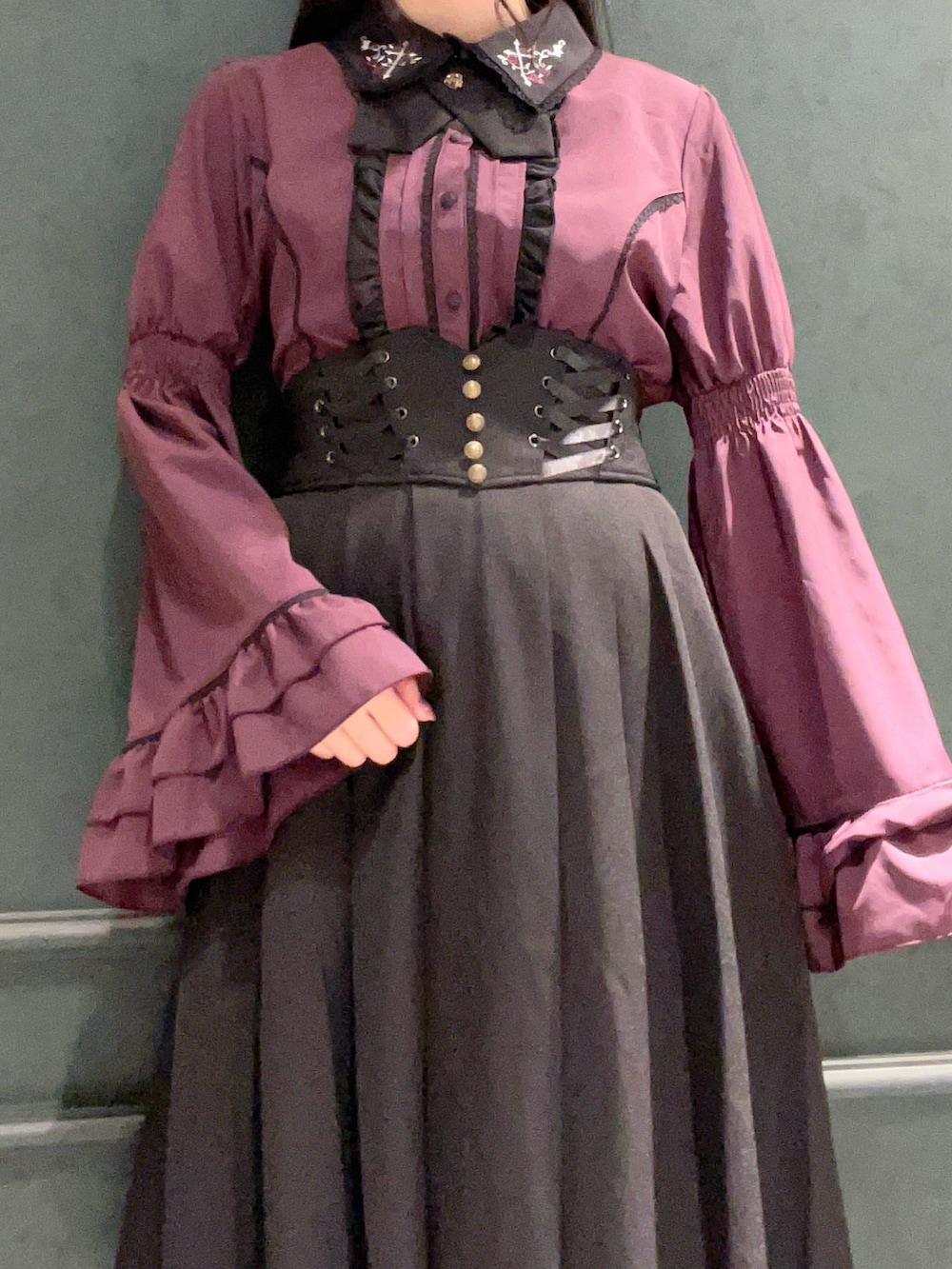 パープル系のシャツ/ブラウス、ブラック系のブーツ、ブラック系のショルダーバッグを着用したレディースの秋コーディネートの3枚目の写真