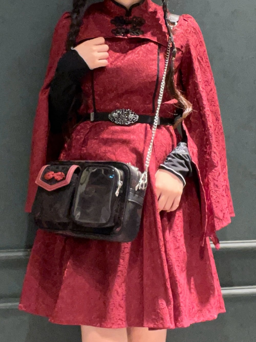 レッド系のブーツ、レッド系のワンピース、レッド系のショルダーバッグを着用したレディースの秋コーディネートの5枚目の写真