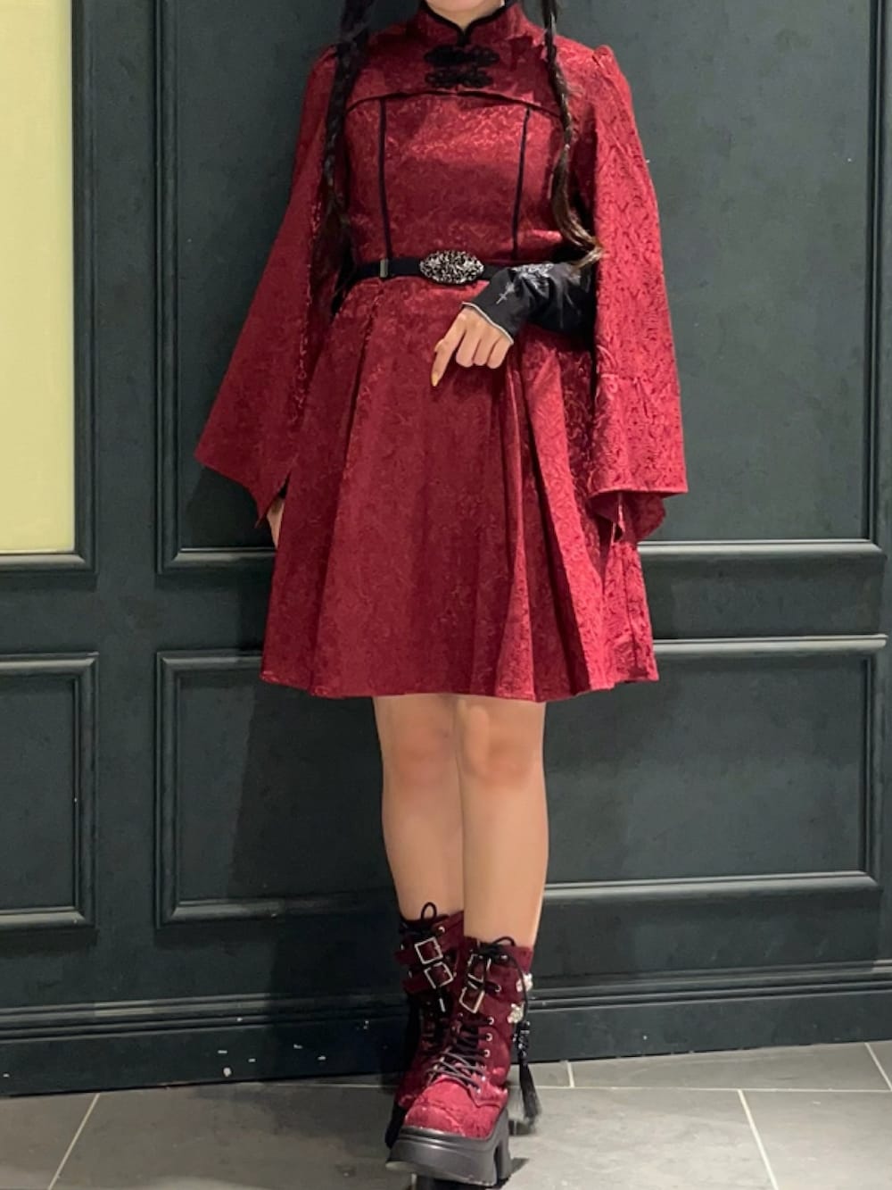 レッド系のブーツ、レッド系のワンピース、レッド系のショルダーバッグを着用したレディースの秋コーディネートの7枚目の写真