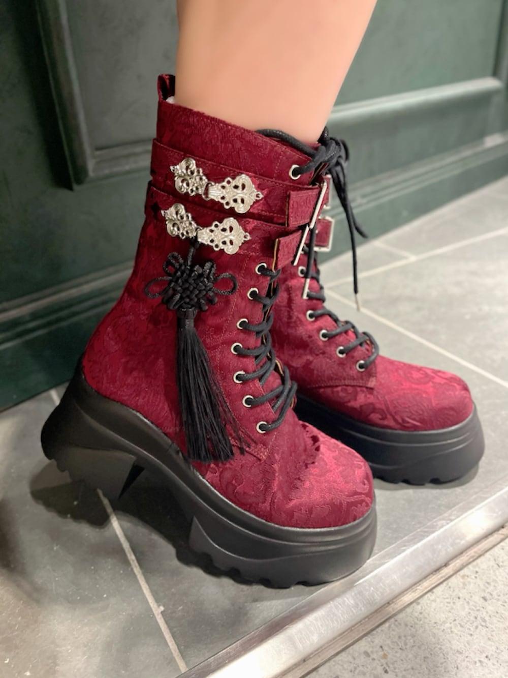 レッド系のブーツ、レッド系のワンピース、レッド系のショルダーバッグを着用したレディースの秋コーディネートの10枚目の写真