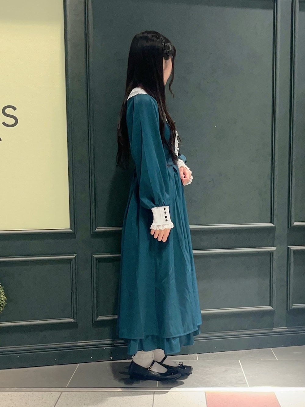 グリーン系のワンピースを着用したレディースの秋コーディネートの2枚目の写真