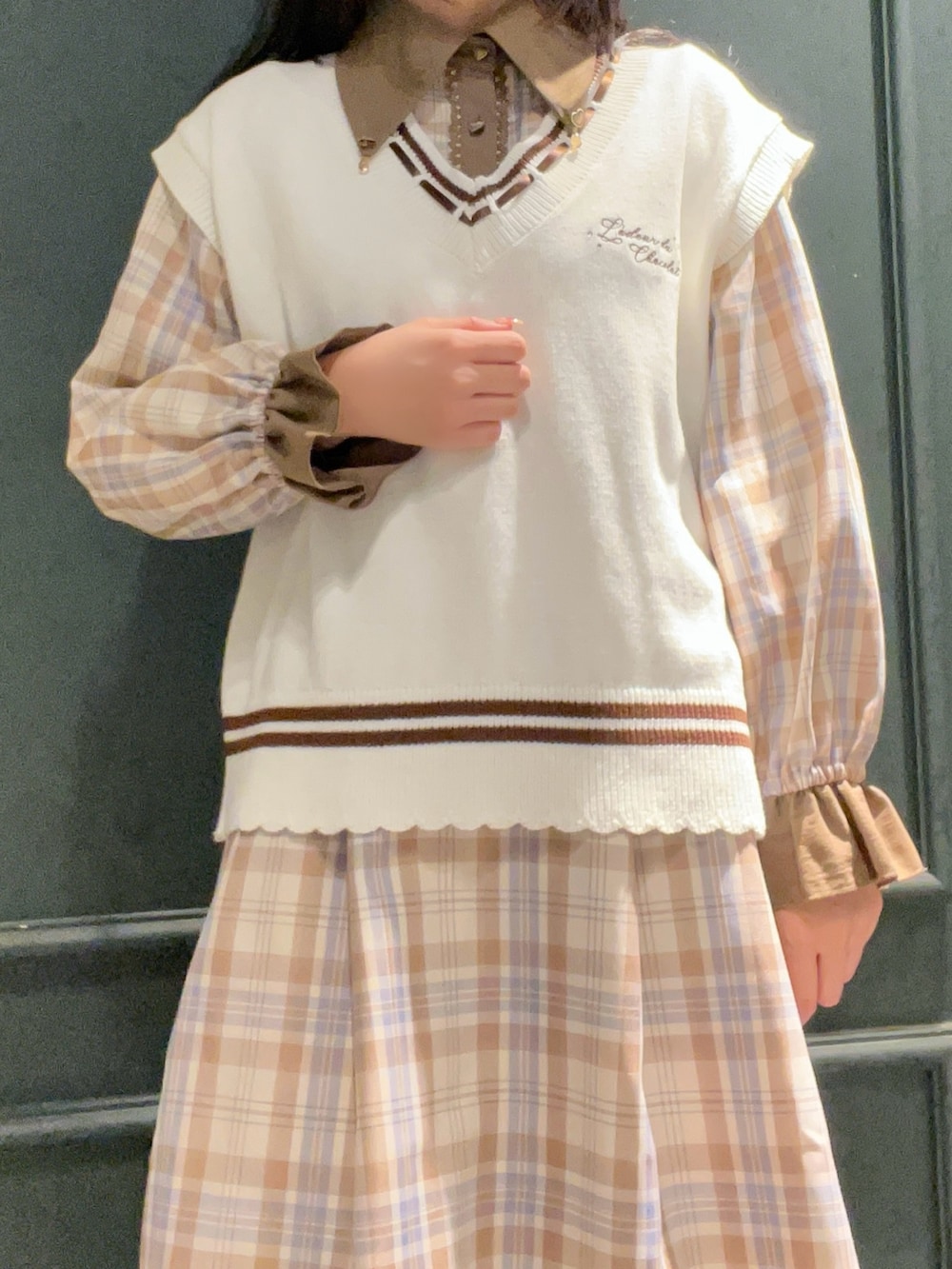 ホワイト系のニット/セーター、ベージュ系のワンピース、ブラウン系のローファーを着用したレディースの冬コーディネートの2枚目の写真