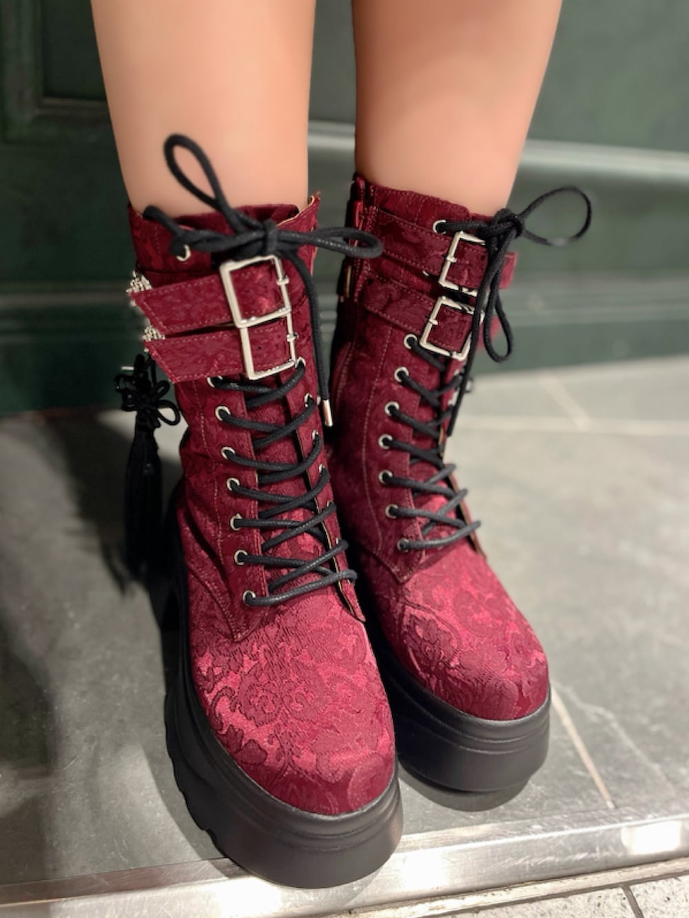 レッド系のブーツ、レッド系のワンピース、レッド系のショルダーバッグを着用したレディースの秋コーディネートの9枚目の写真