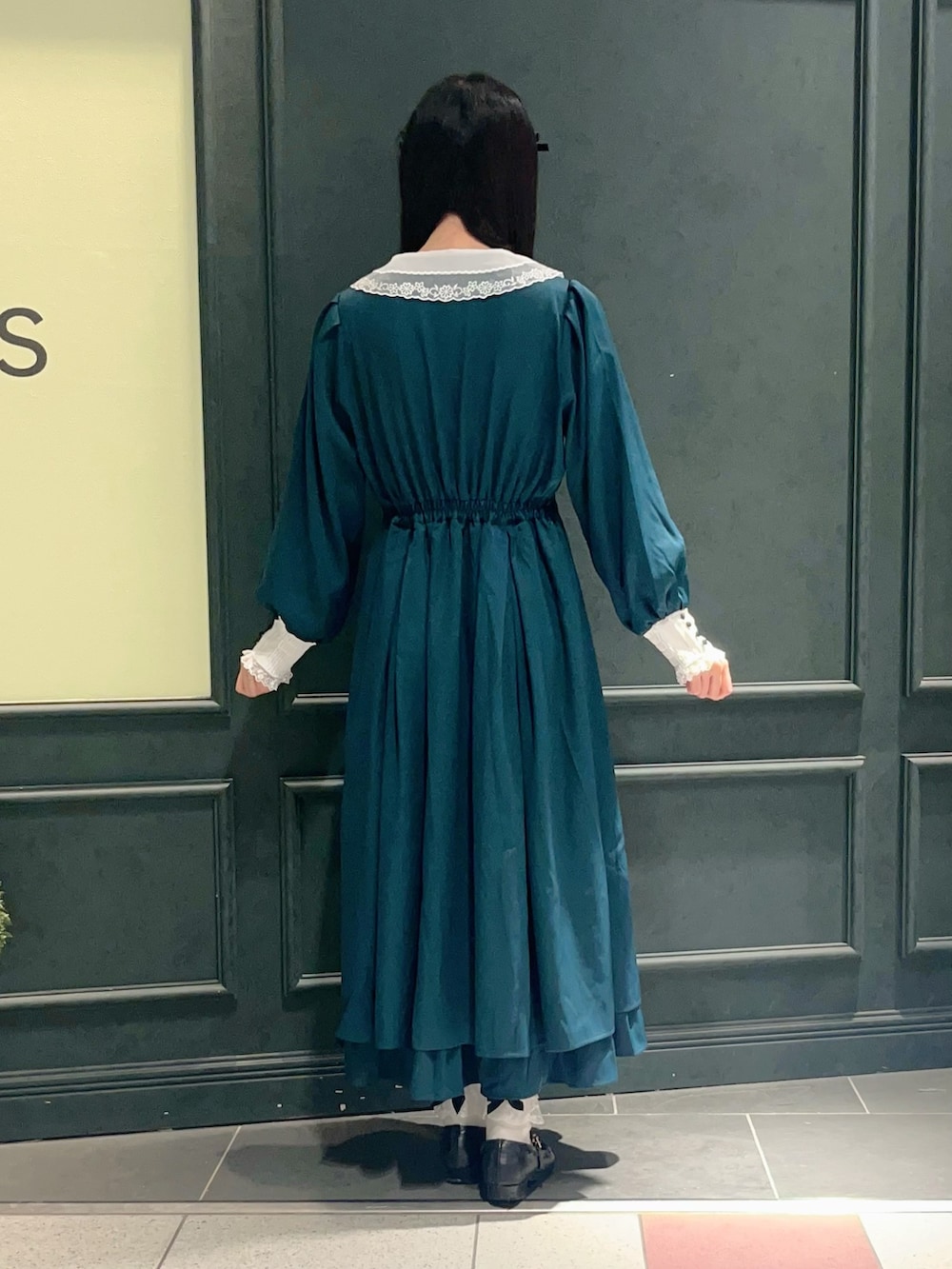 グリーン系のワンピースを着用したレディースの秋コーディネートの3枚目の写真