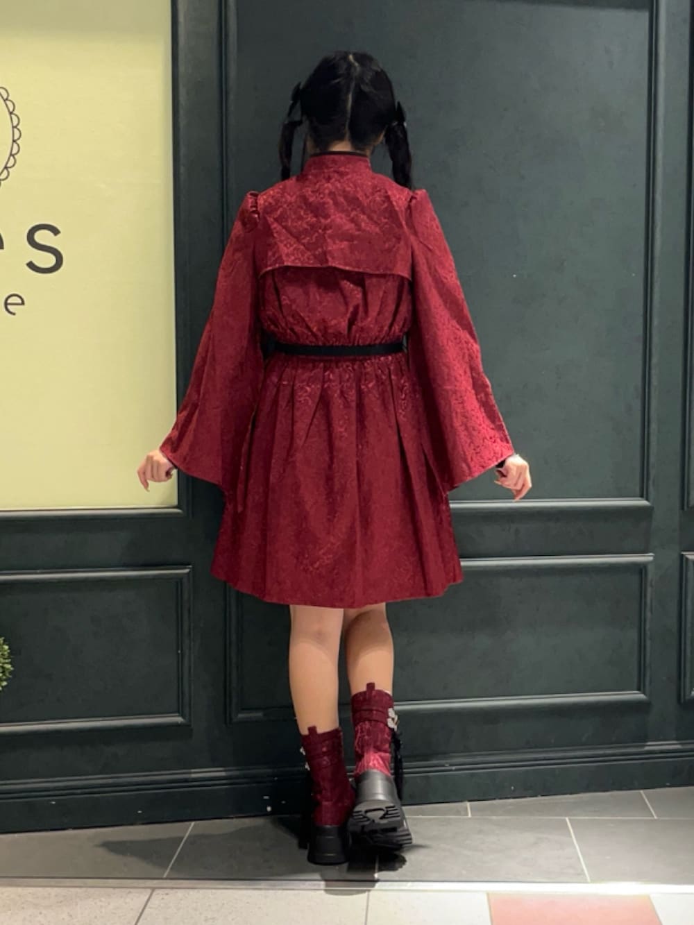 レッド系のブーツ、レッド系のワンピース、レッド系のショルダーバッグを着用したレディースの秋コーディネートの3枚目の写真