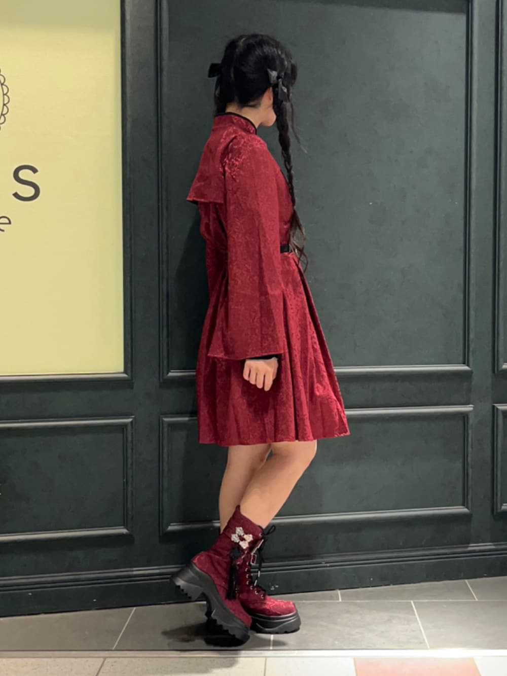 レッド系のブーツ、レッド系のワンピース、レッド系のショルダーバッグを着用したレディースの秋コーディネートの4枚目の写真