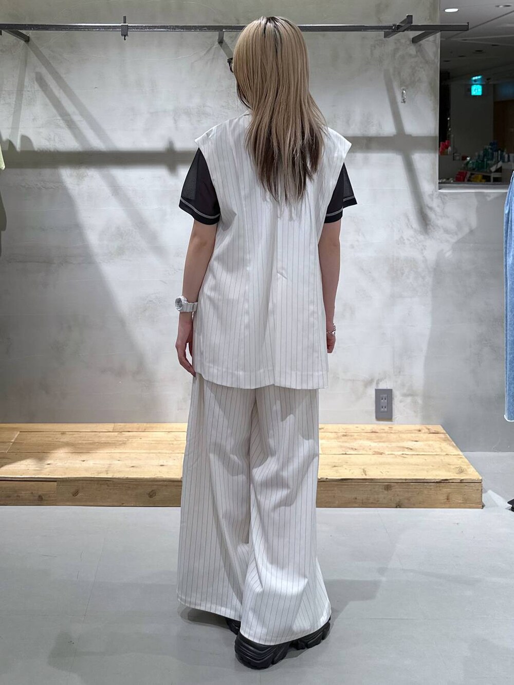 ブラック系のTシャツ/カットソー、その他のスラックス、ホワイト系のベストを着用したレディースの春コーディネートの2枚目の写真