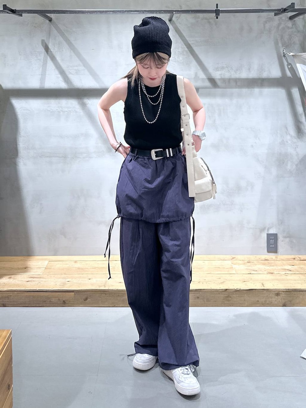 ブラック系のタンクトップ、ホワイト系のショルダーバッグ、ブルー系のサロペット/オーバーオールを着用したレディースの春コーディネートの4枚目の写真