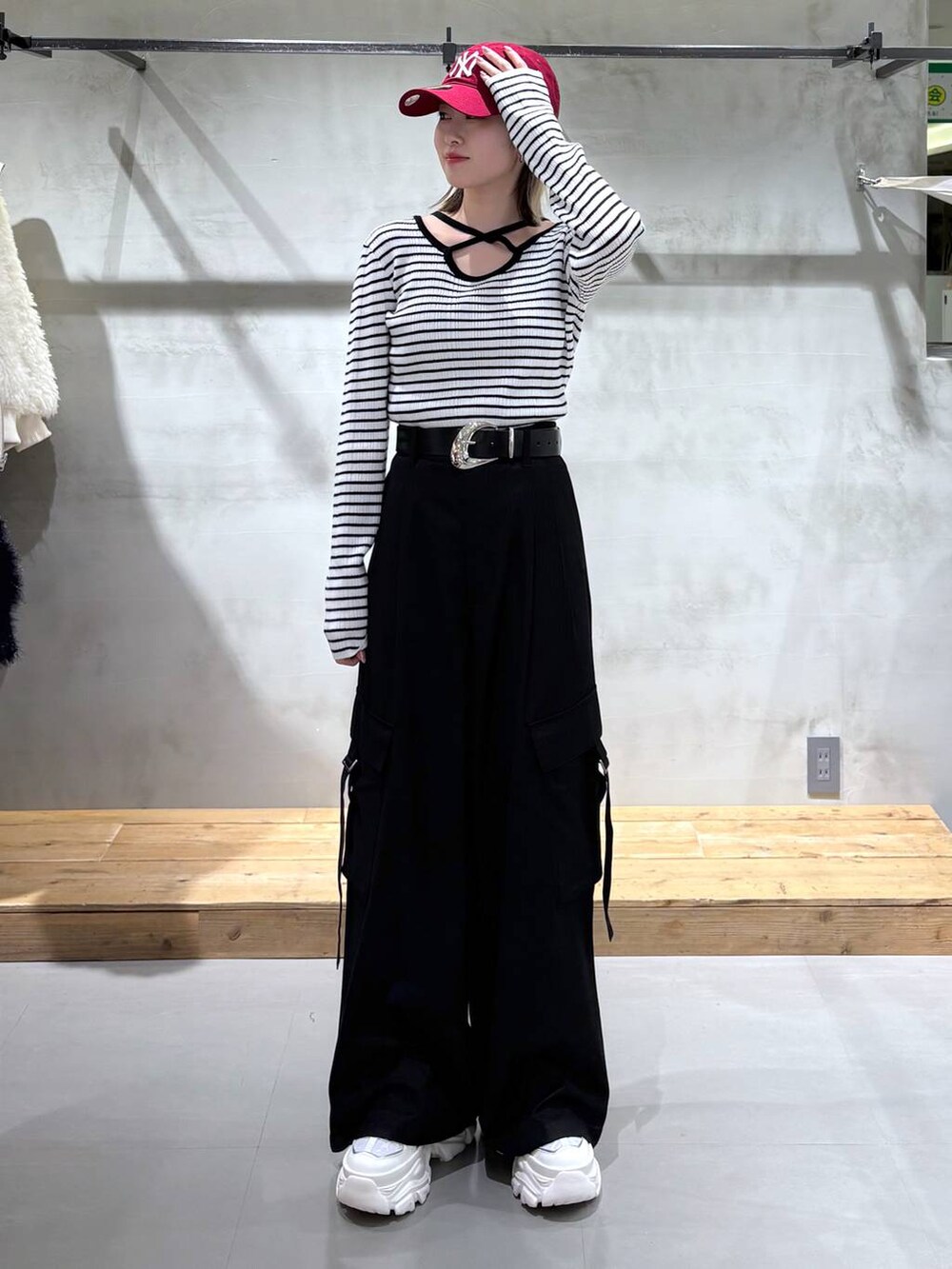 ホワイト系のスニーカー、ブラック系のスラックス、ホワイト系のニット/セーターを着用したレディースの冬コーディネートの4枚目の写真