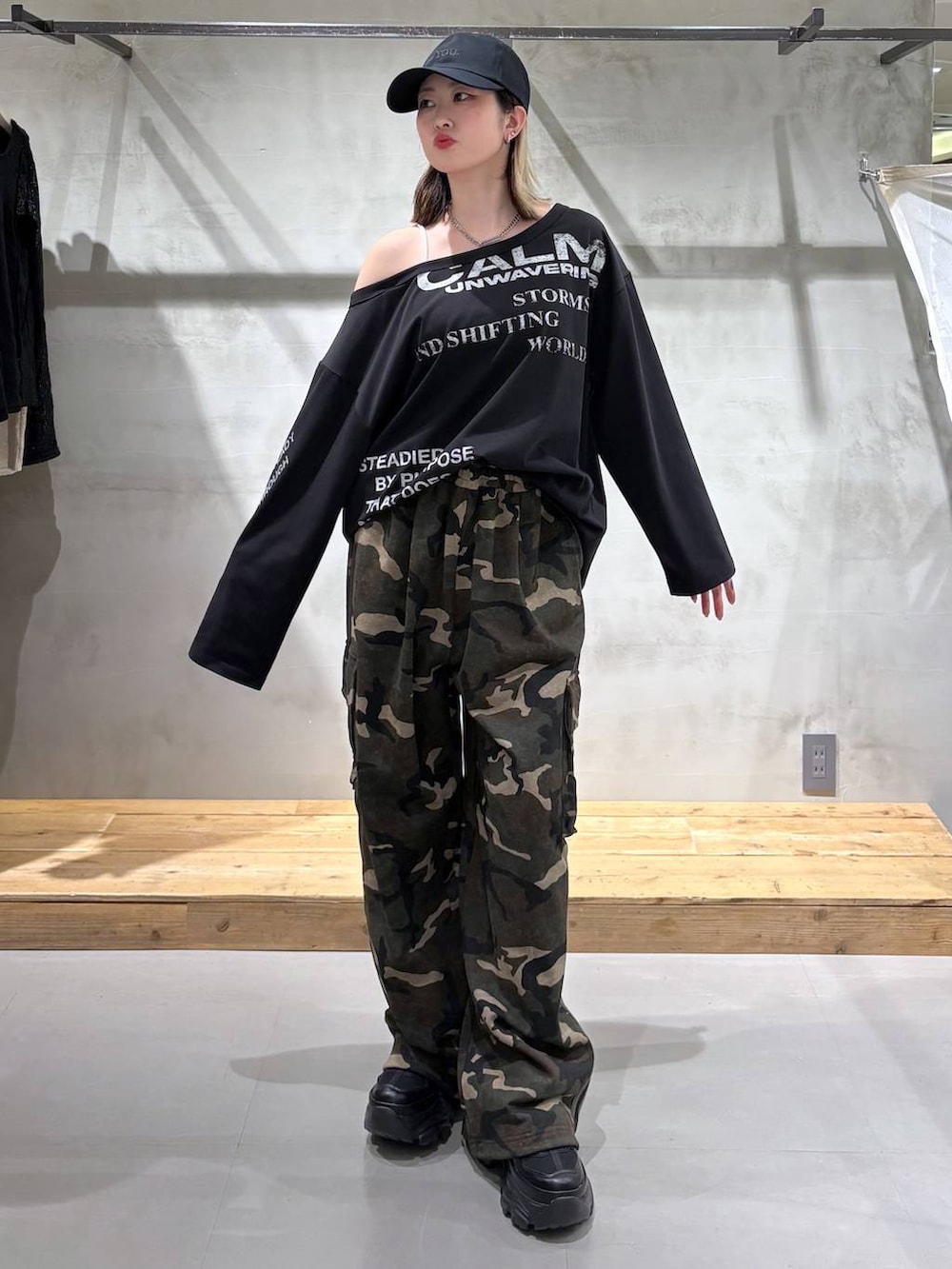 ブラック系のスニーカー、グリーン系のスウェットパンツ、ブラック系のTシャツ/カットソーを着用したレディースの春コーディネートの2枚目の写真