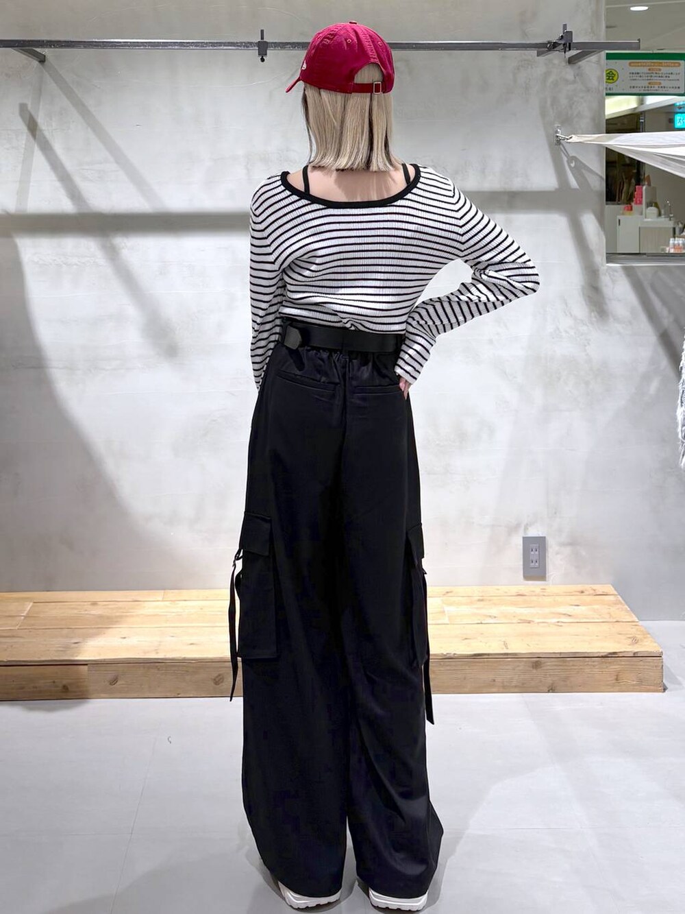 ホワイト系のスニーカー、ブラック系のスラックス、ホワイト系のニット/セーターを着用したレディースの冬コーディネートの2枚目の写真