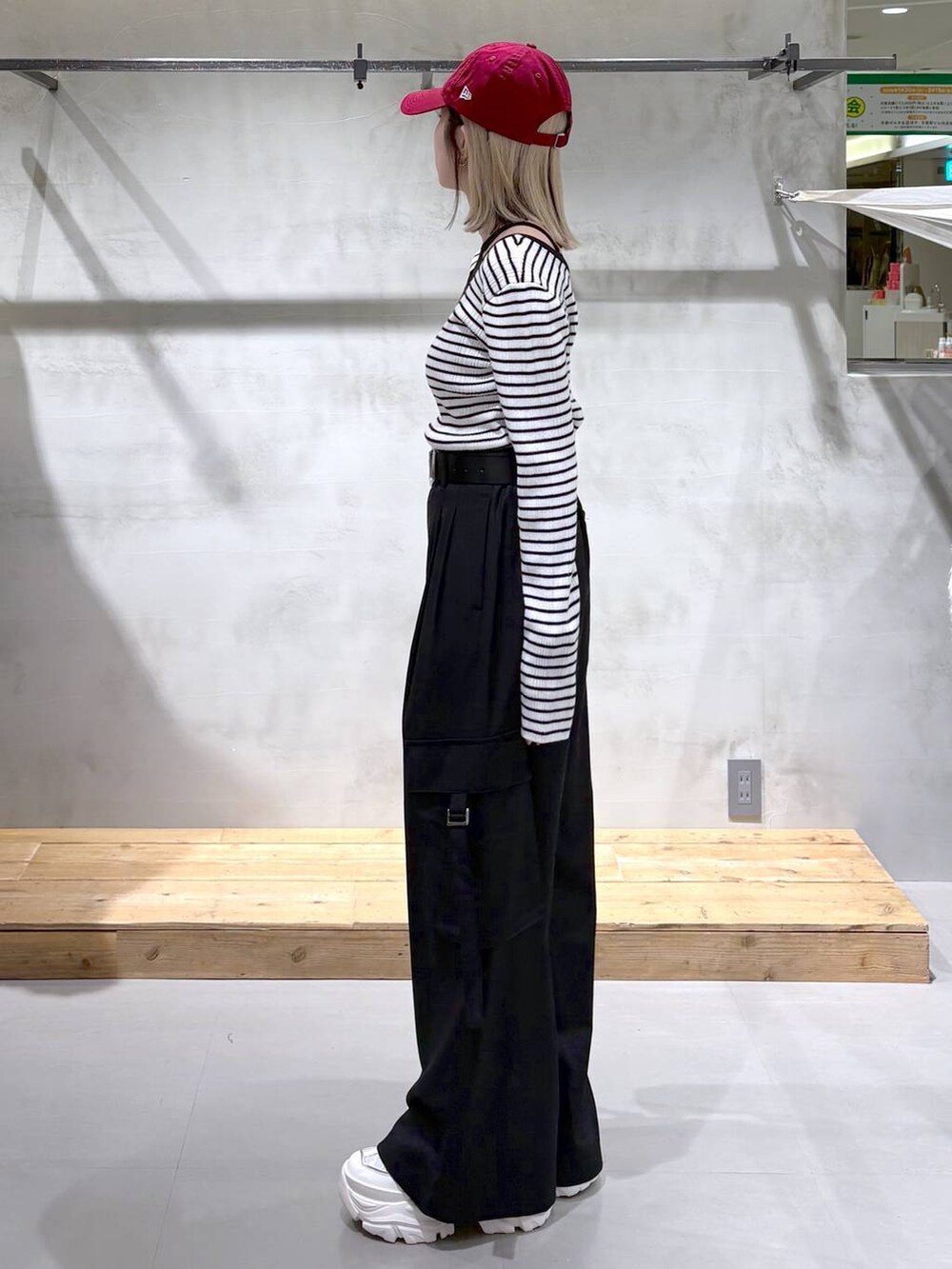 ホワイト系のスニーカー、ブラック系のスラックス、ホワイト系のニット/セーターを着用したレディースの冬コーディネートの3枚目の写真