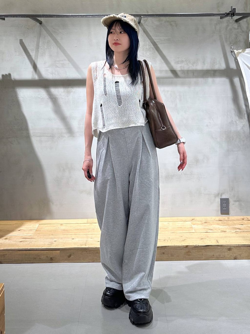 ブラック系のスニーカー、ブラウン系のボストンバッグ、グレー系のスウェットパンツを着用したレディースの夏コーディネートの3枚目の写真