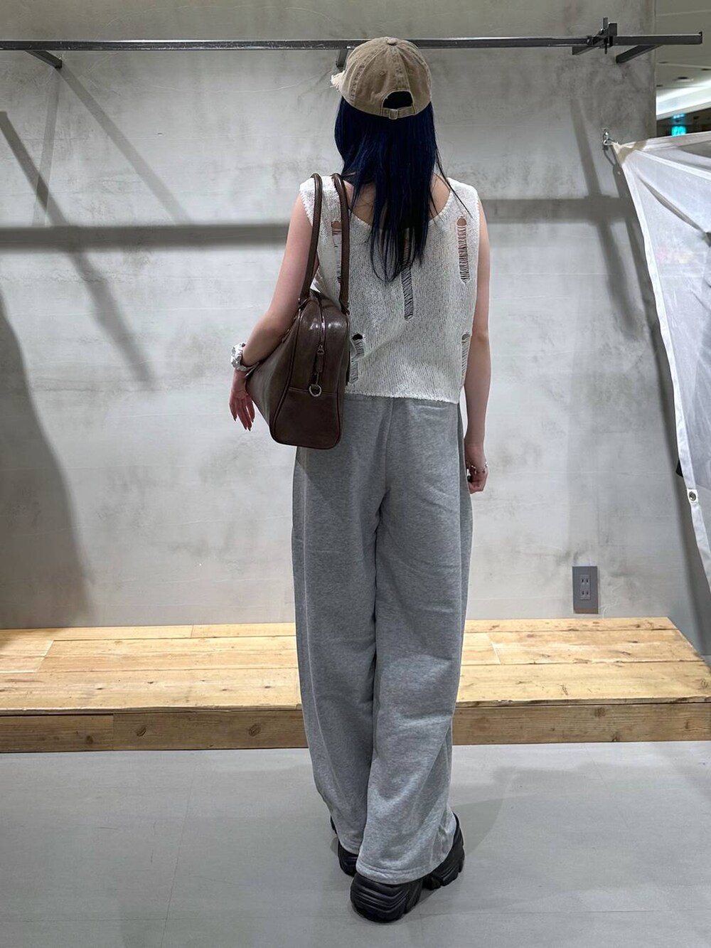 ブラック系のスニーカー、ブラウン系のボストンバッグ、グレー系のスウェットパンツを着用したレディースの夏コーディネートの2枚目の写真