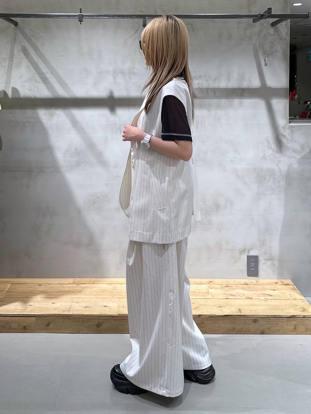 ブラック系のTシャツ/カットソー、その他のスラックス、ホワイト系のベストを着用したレディースの春コーディネートの3枚目の写真