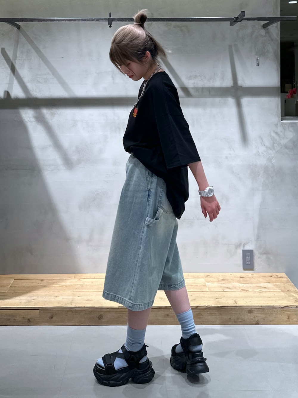 ブルー系のその他パンツ、ブラック系のTシャツ/カットソー、ブラック系のサンダルを着用したレディースの春コーディネートの3枚目の写真