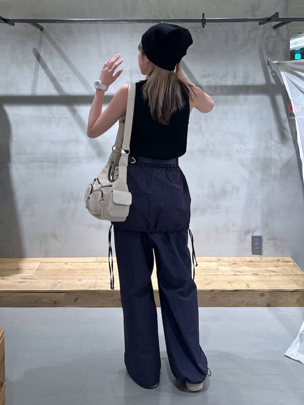 ブラック系のタンクトップ、ホワイト系のショルダーバッグ、ブルー系のサロペット/オーバーオールを着用したレディースの春コーディネートの2枚目の写真